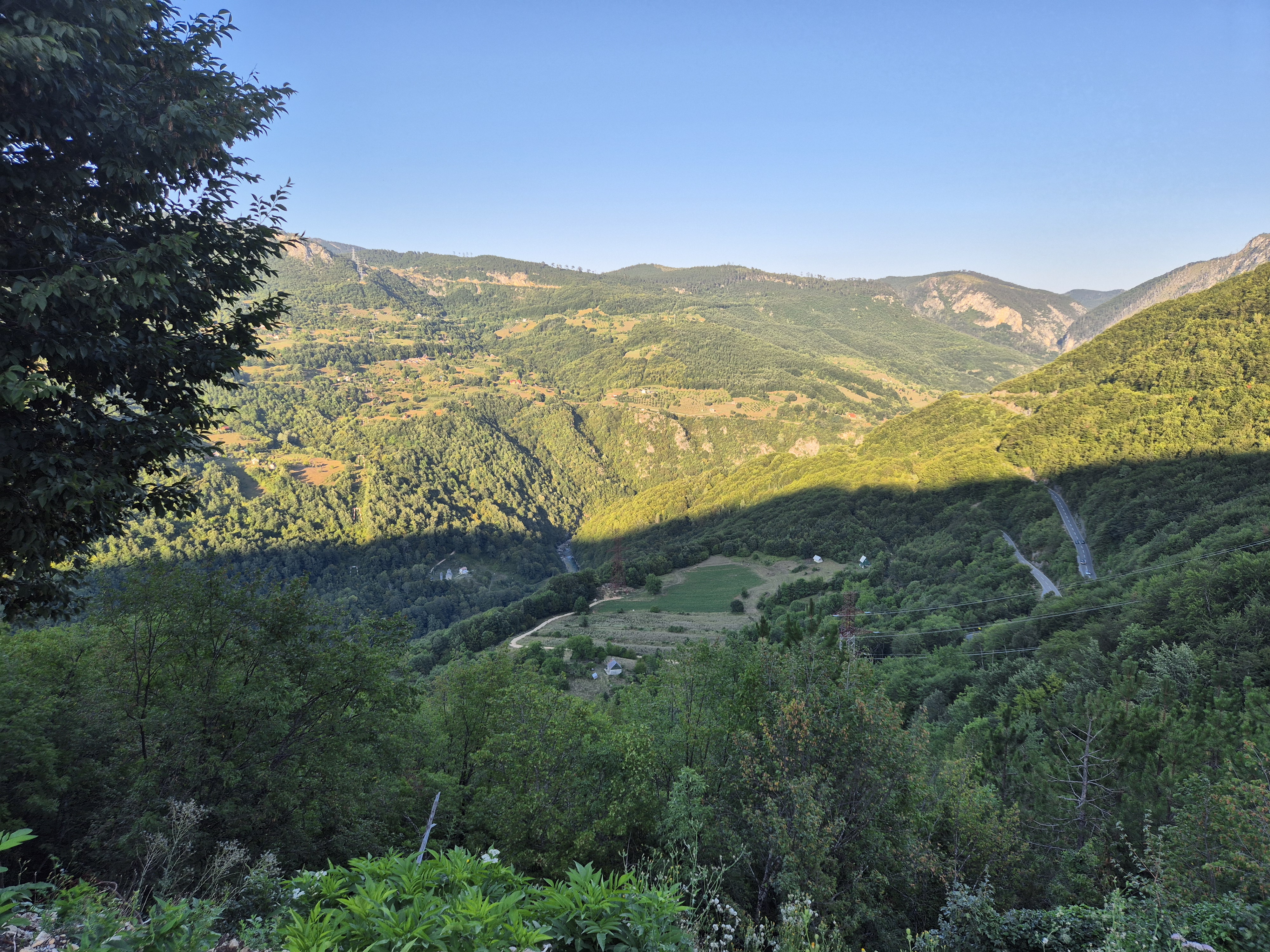 From somewhere in the middle of the uphill struggle, you can see the river already in the shadow of the mountain and the large switchbacks